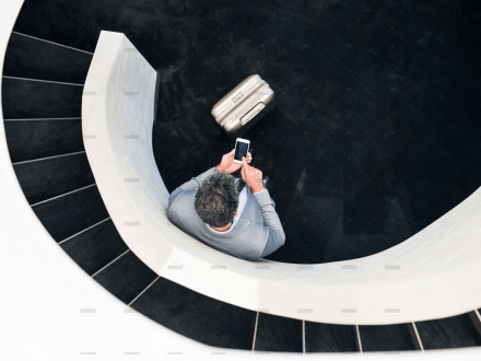 demo-attachment-501-Businessman-with-smartphone-standing-at-staircase.@2x